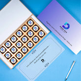 Open wooden gift box showing assorted logo chocolates—annual day gifts for employees