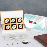 White gift box of four logo chocolates with company branding for corporate event