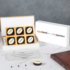 AppViewX rebranding corporate gift – open white box displaying six custom logo chocolates and printed relaunch card by ChocoCraft. 