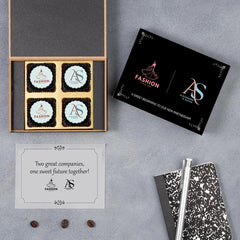 Stacked logo‑branded chocolate boxes prepared for bulk corporate merger announcement gifts.