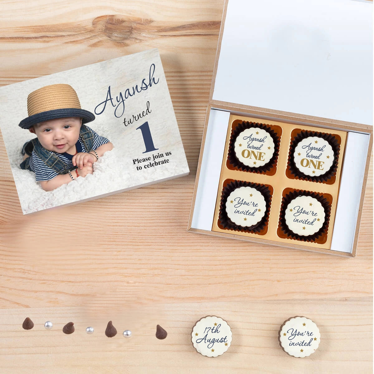 Open wooden box showcasing creative 1st birthday invitation chocolates