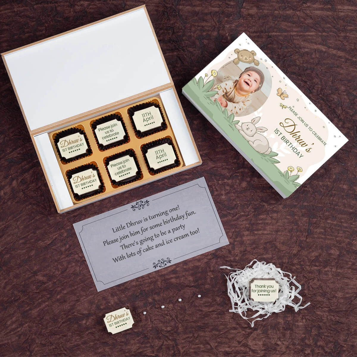Open box showing customized 1st birthday invitation card chocolates