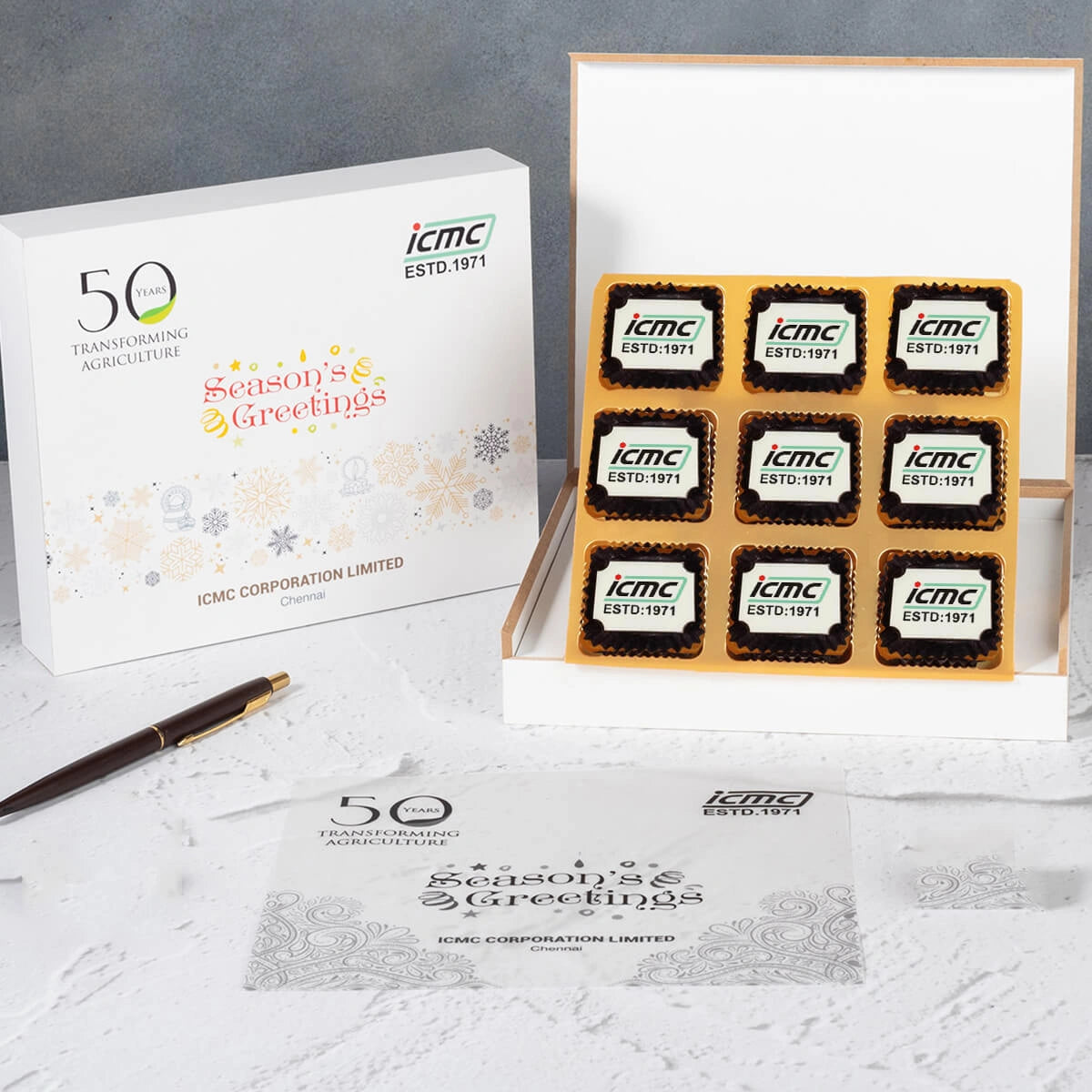 Open six‑piece logo‑chocolate box presented for employee work‑anniversary celebrations.
