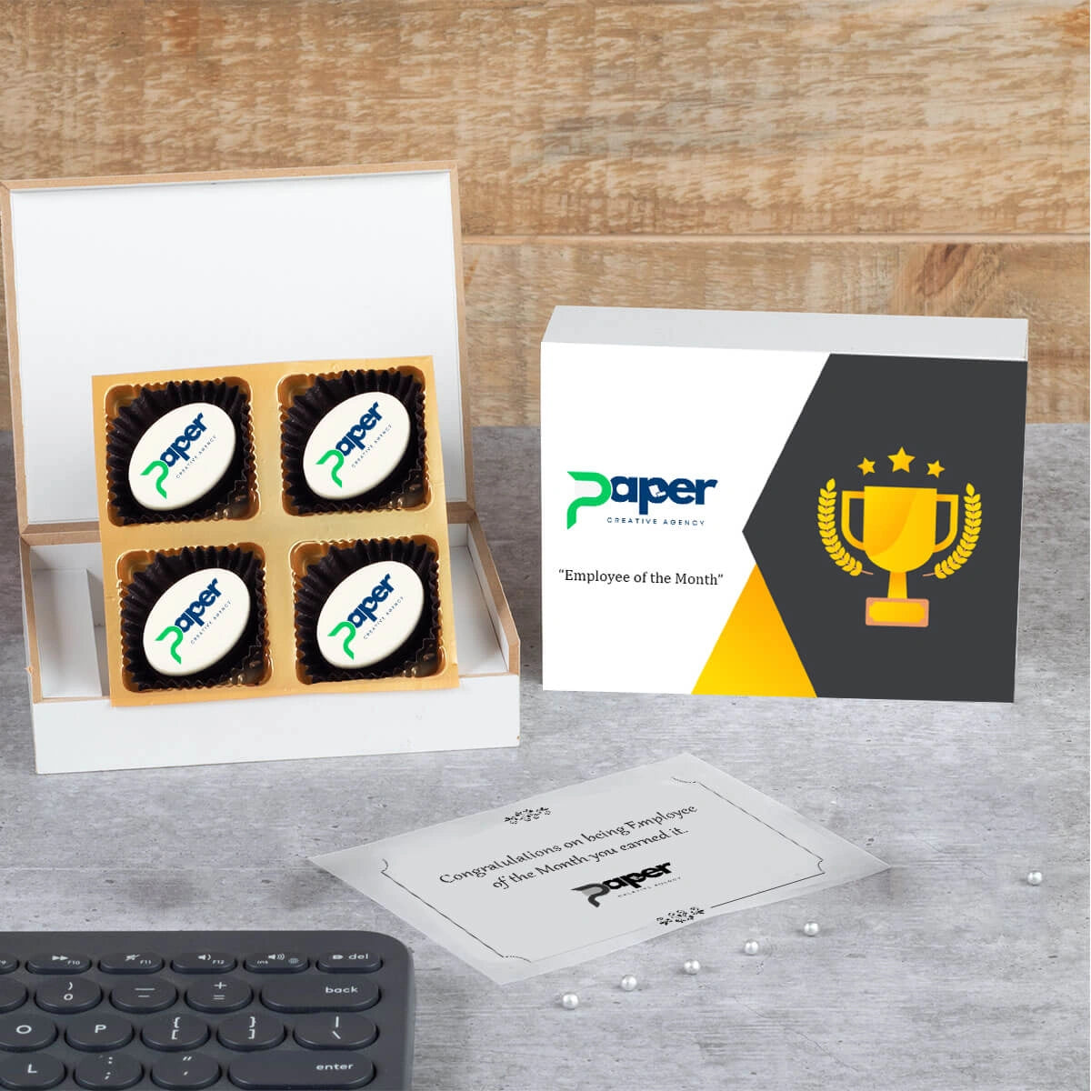 Open wooden gift box with logo chocolates and “Congratulations” lid message