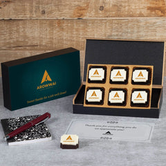 Open MDF box revealing six logo chocolates and thank‑you note for employees.