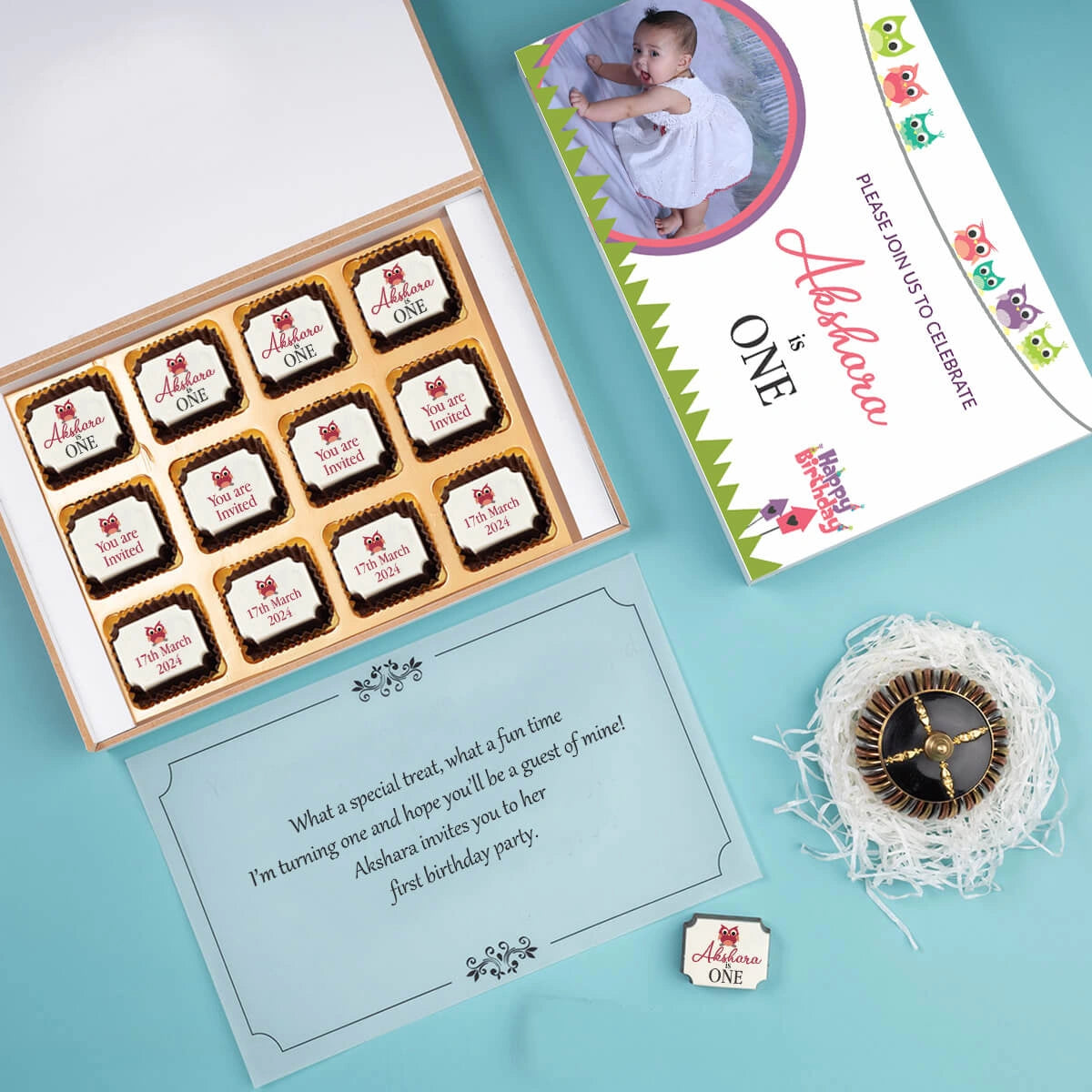 Open view showing first birthday invitation card with photo chocolates