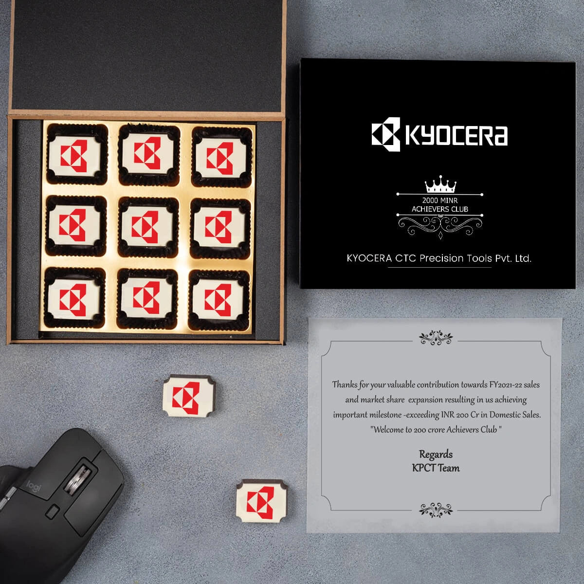 Elegant 12‑piece wooden box of logo chocolates celebrating a milestone company anniversary.