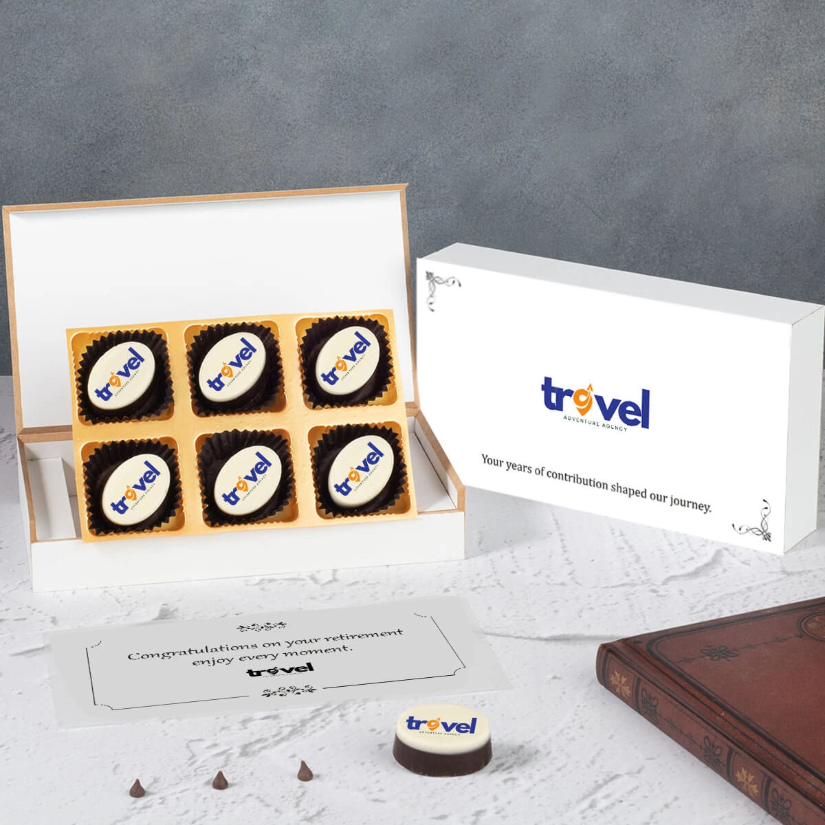 Open white wooden box showing mix of printed chocolates for retirement gift.