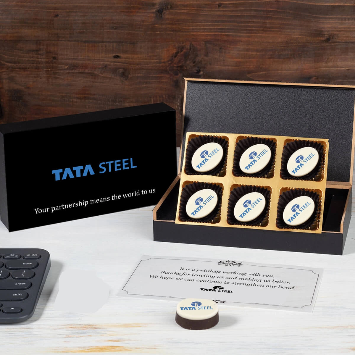 Open MDF box showing two thank‑you logo chocolates with personalised butter paper