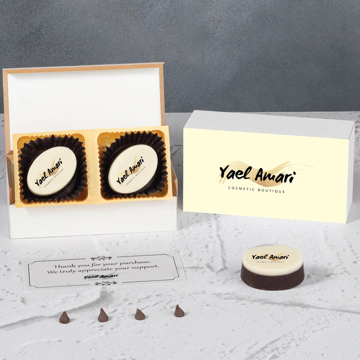 Open wooden box revealing thank‑you logo chocolates and printed chocolate pieces