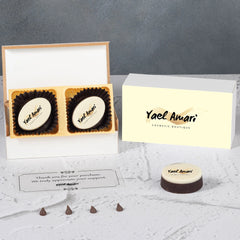 Open wooden box revealing thank‑you logo chocolates and printed chocolate pieces