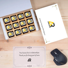 Top‑view white Anna Rosa gift box and twelve logo chocolates conveying elegance for luxury brand client gifting.